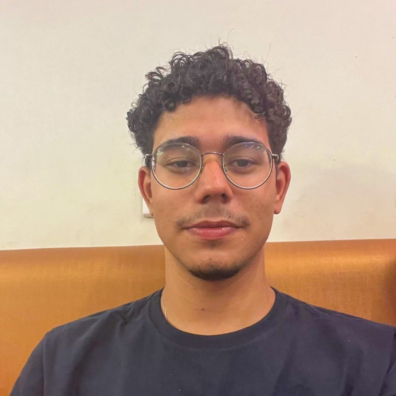 Leandro em um fundo marrom e branco